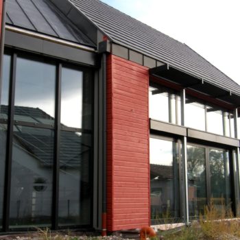 Maison ossature bois, bardage gris et rouge en bois