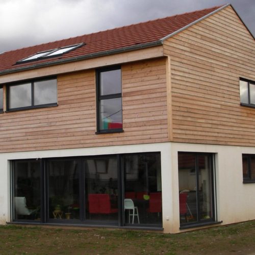 maison individuelle construction bois, grande baie vitrée, revêtement bardage bois et crépis