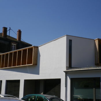 Extension et rénovation en bois d'un ancien garage, revêtement crépi et contours de fenêtres en bois